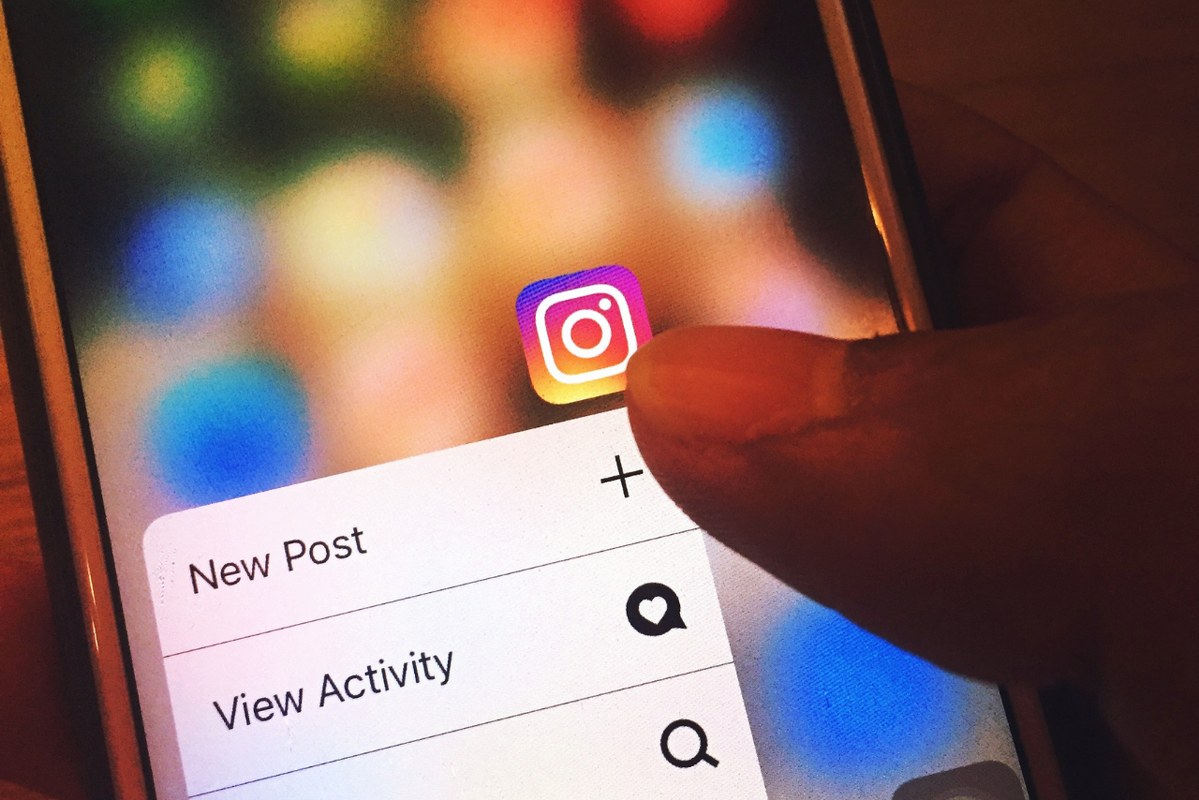 A person is creating a new post on instagram from smartphone.