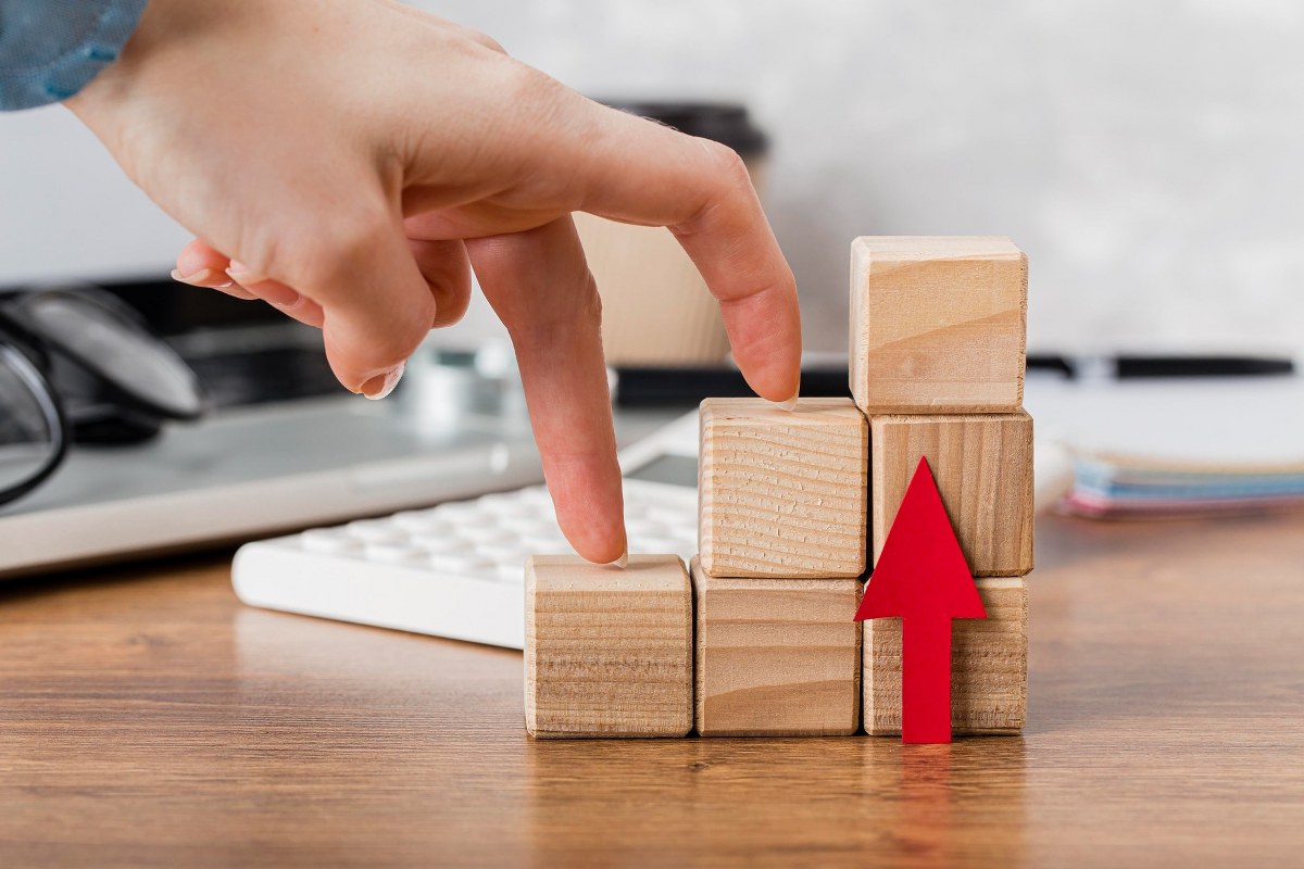 A photo of fingers climbing a wooden toy stairs.