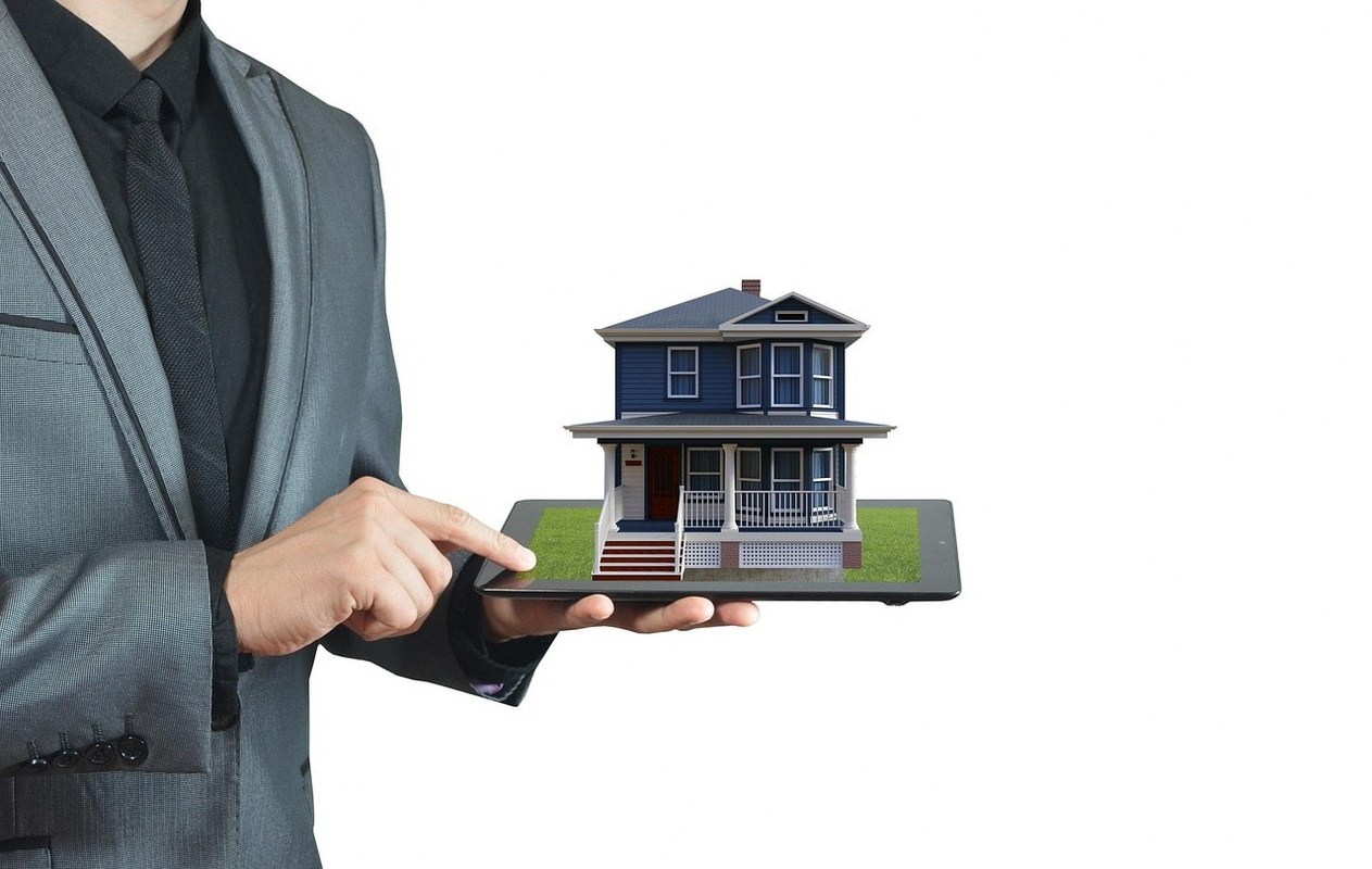 A real-estate agent holding a toy house.