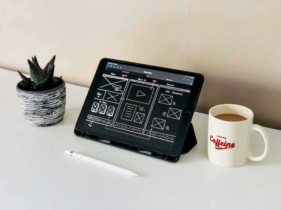 A sketch of a website design is displayed on a tablet.