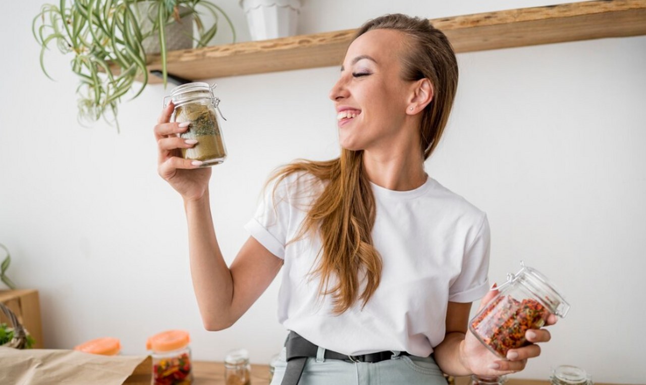 A woman holding jars of mushroom powder.
