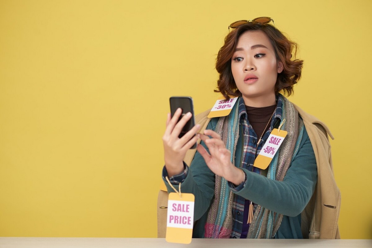 A woman is focused on something on her phone.
