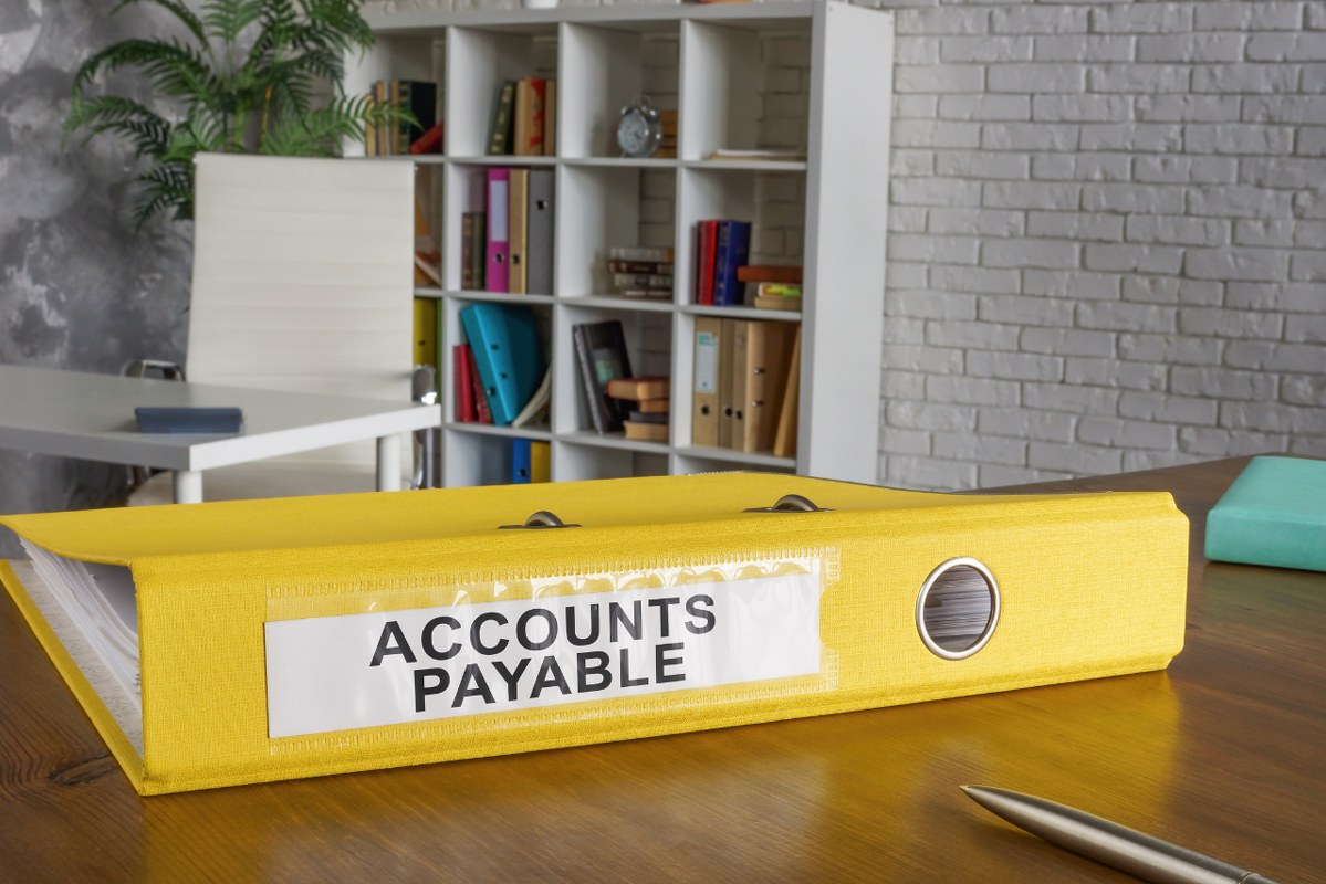 Accounts Payable titled yellow folder on table.