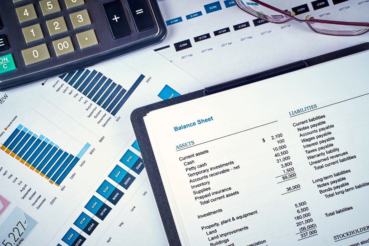 Balance sheet on top of other documents and a calculator.