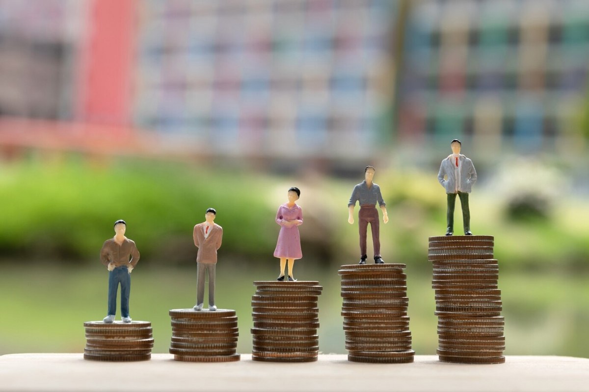 Coins and human miniature models standing on them.
