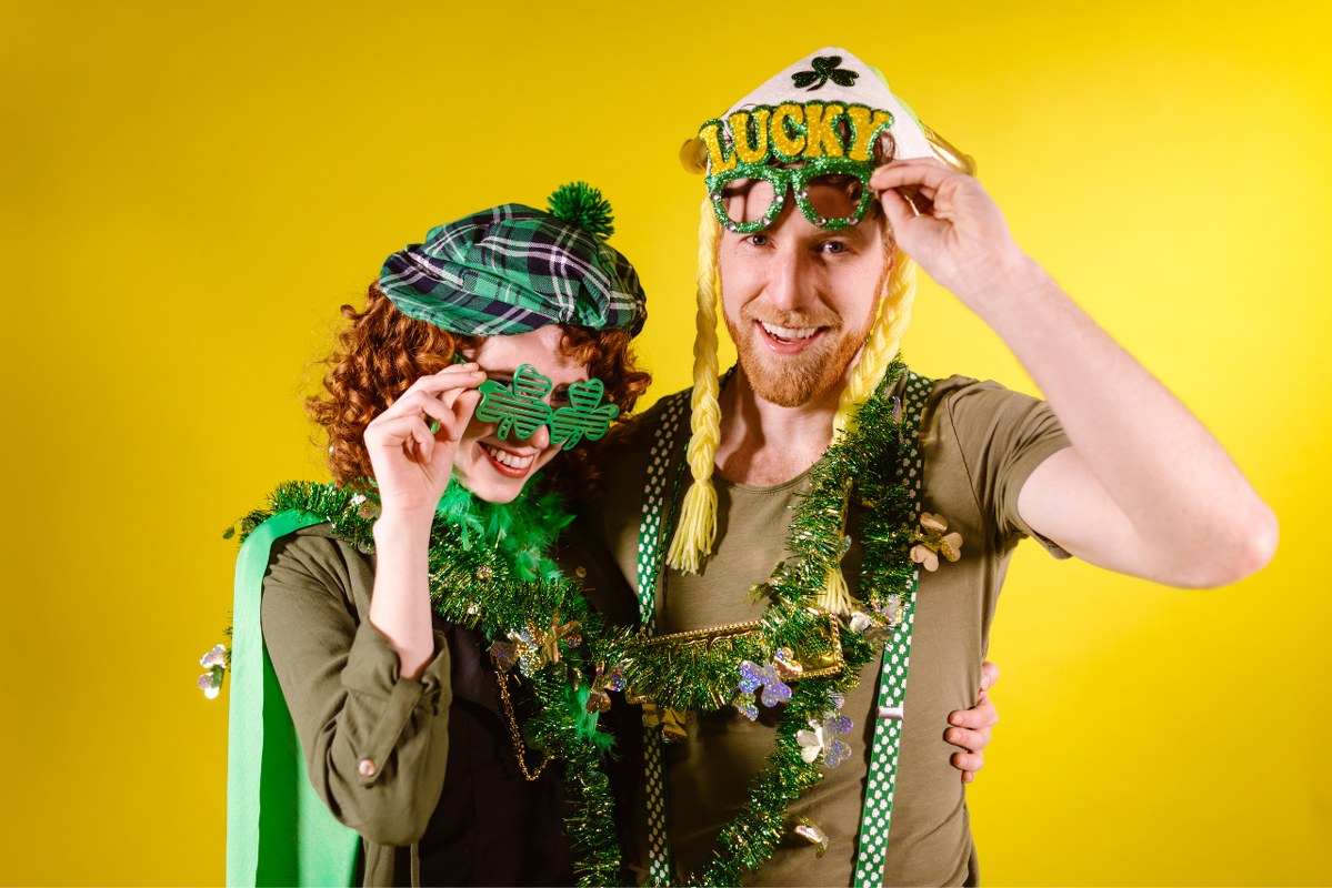 Couple posing at a photobooth during St Patrick's Day.