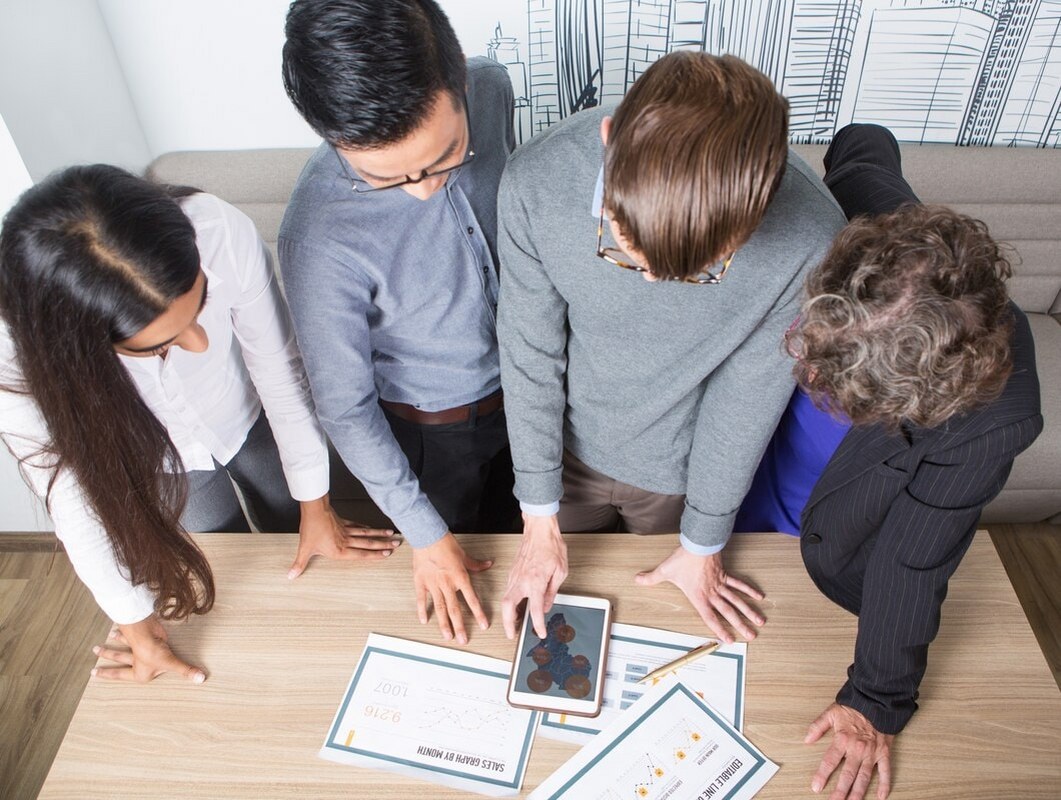 Four business colleagues discussing diagrams.
