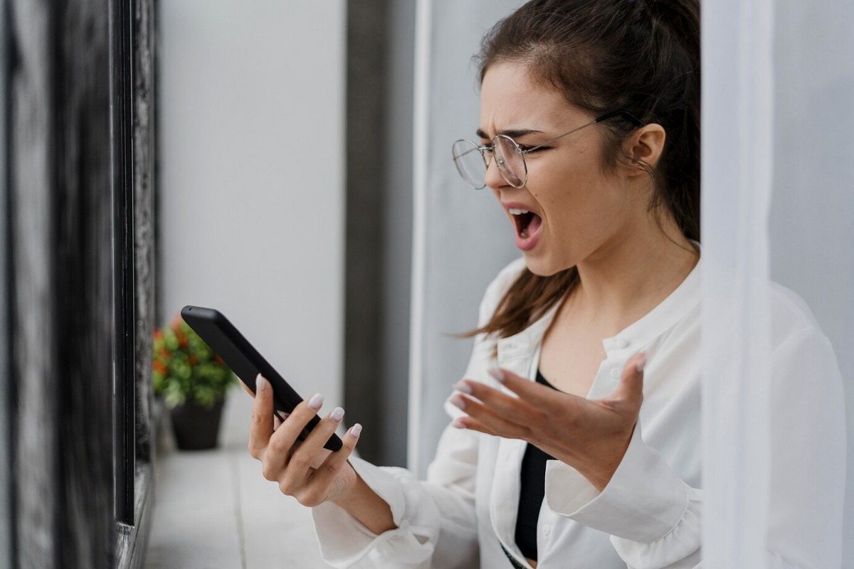 Frustrated girl is staring at her phone.