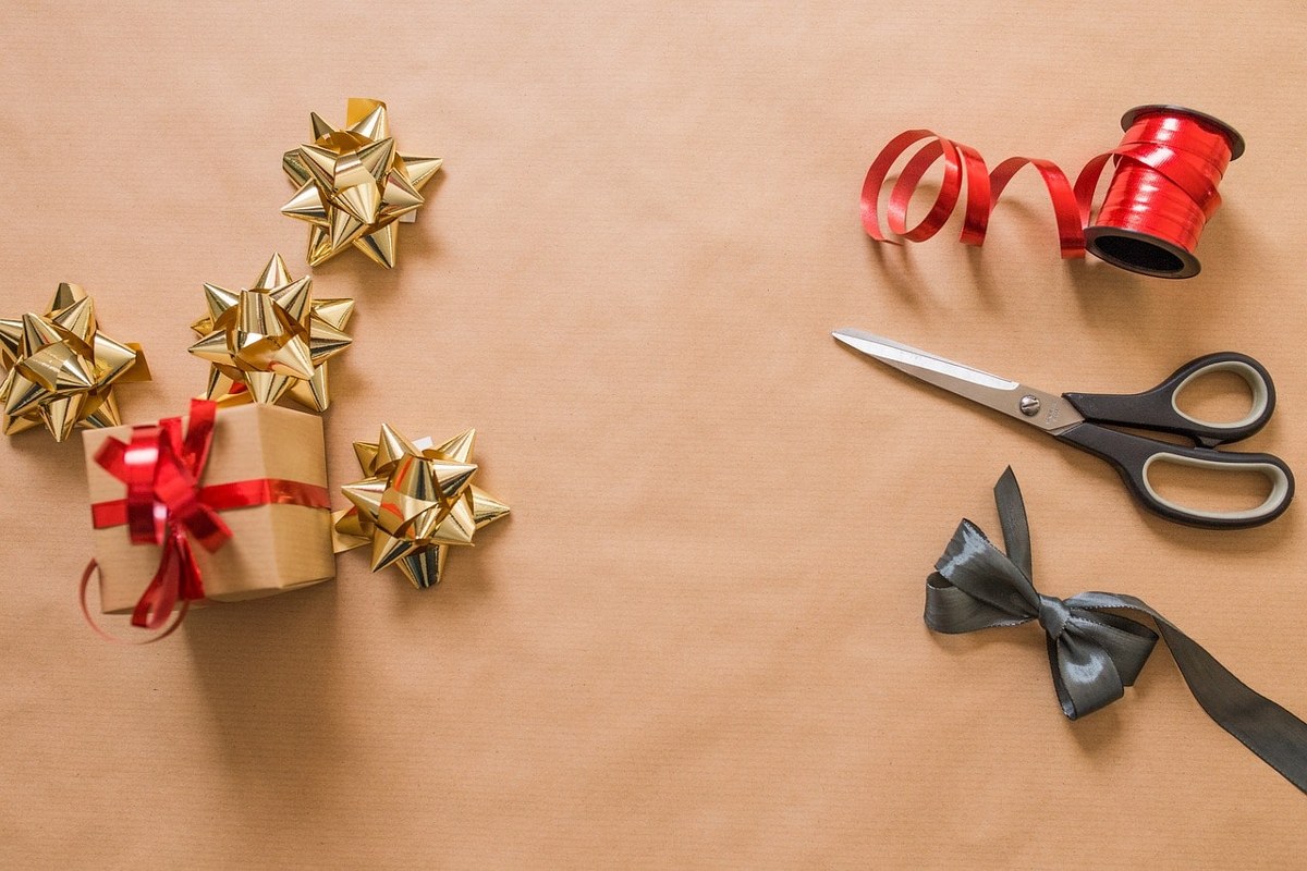 Gift wrapping process with scissors and ribbons.