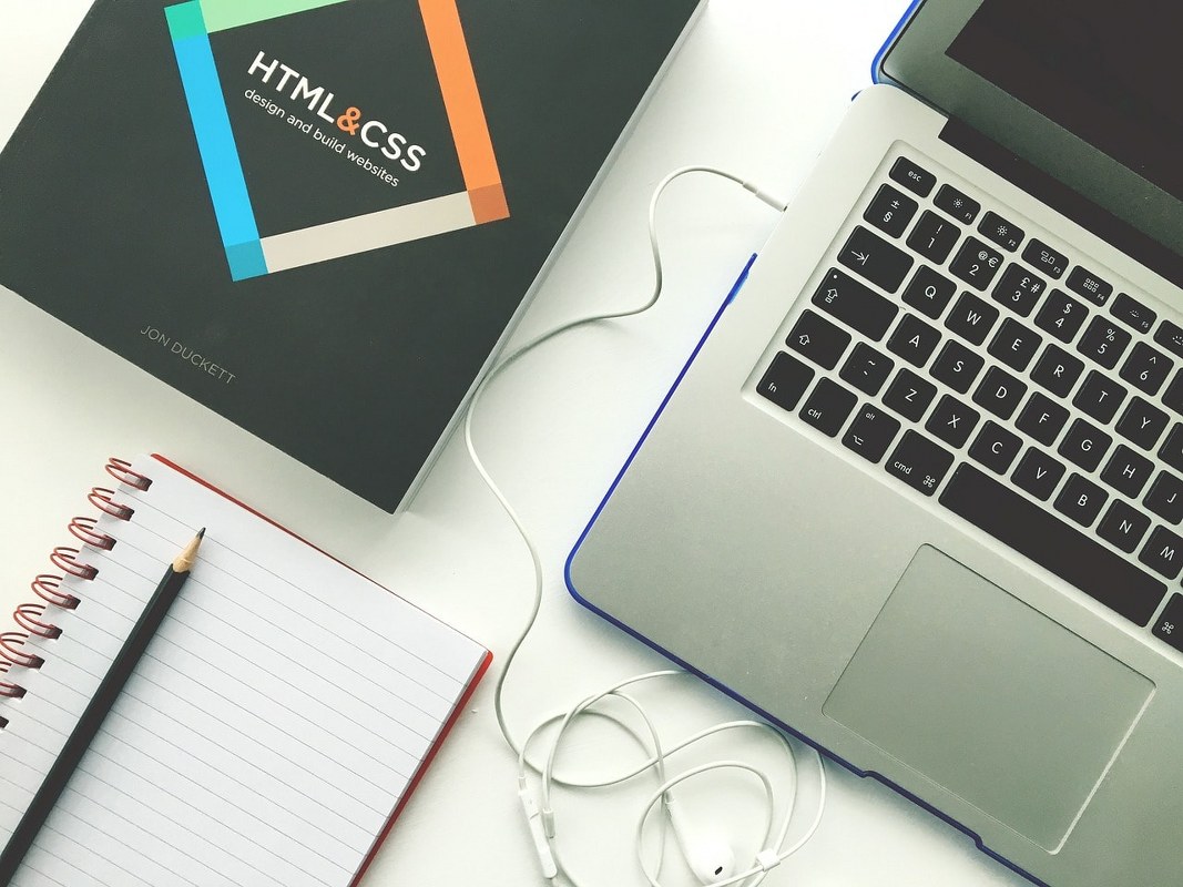 HTML reference book and a laptop computer.