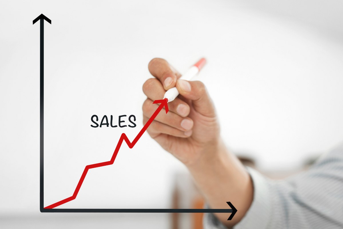 Hand drawing a Sales graph going up.