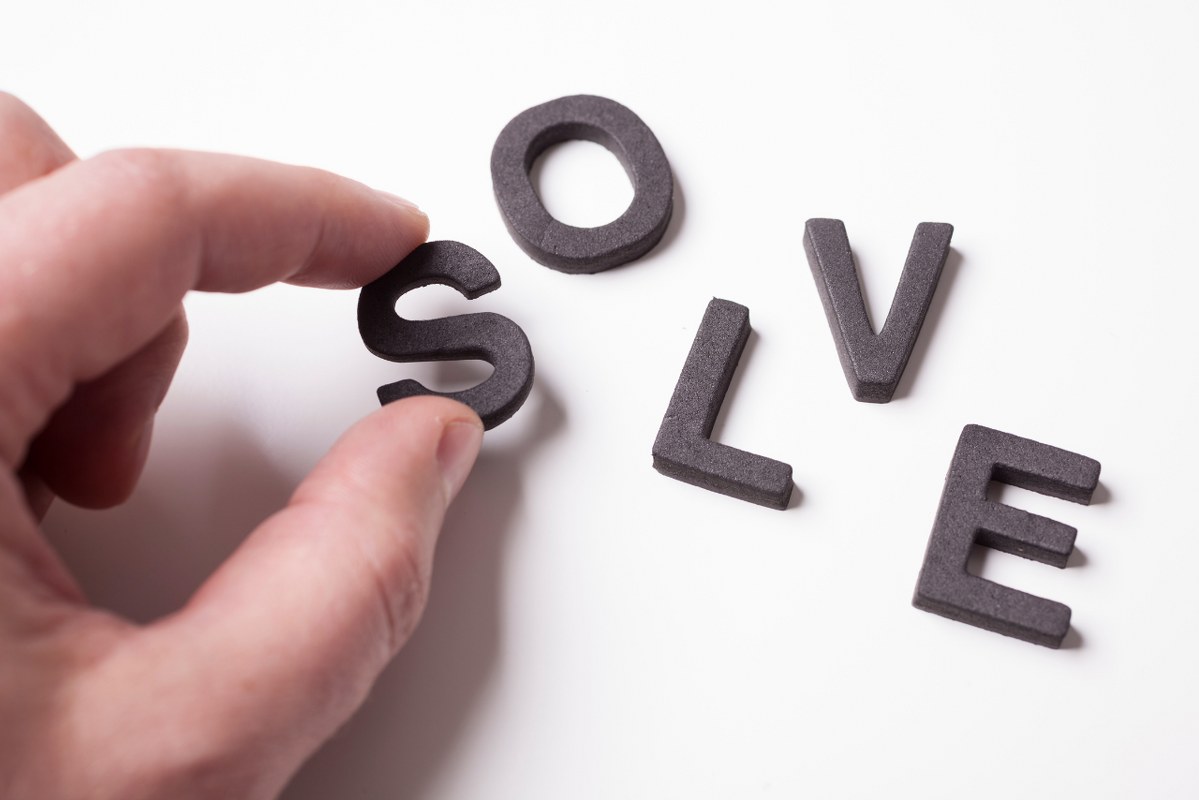 Hand forming word 'SOLVE