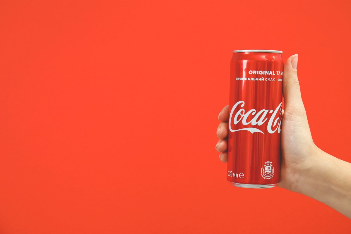 Hand holding a Coca-cola can.