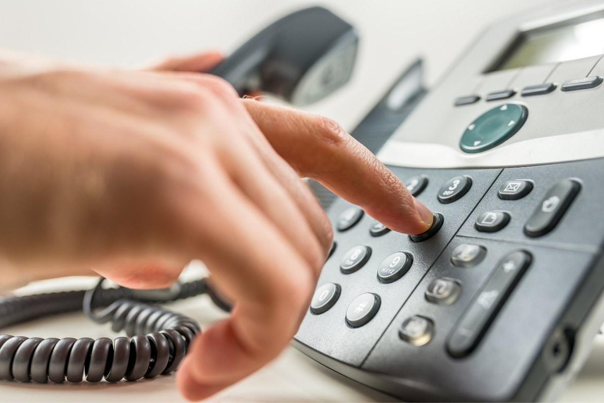 Making phone call on telephone.
