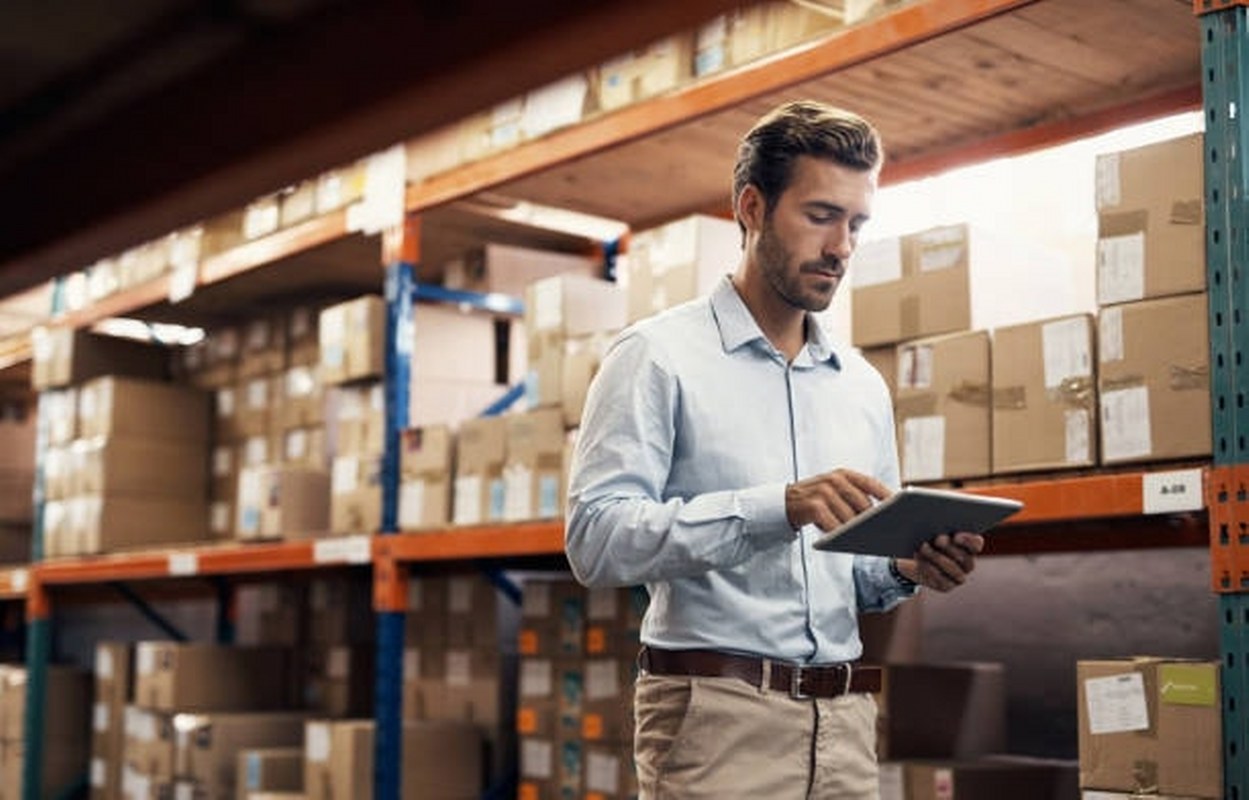 Man checking inventory of goods inside warehouse.