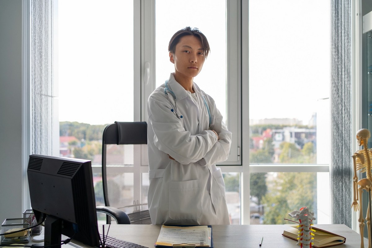 Man in a suit wears a stethoscope around his neck.