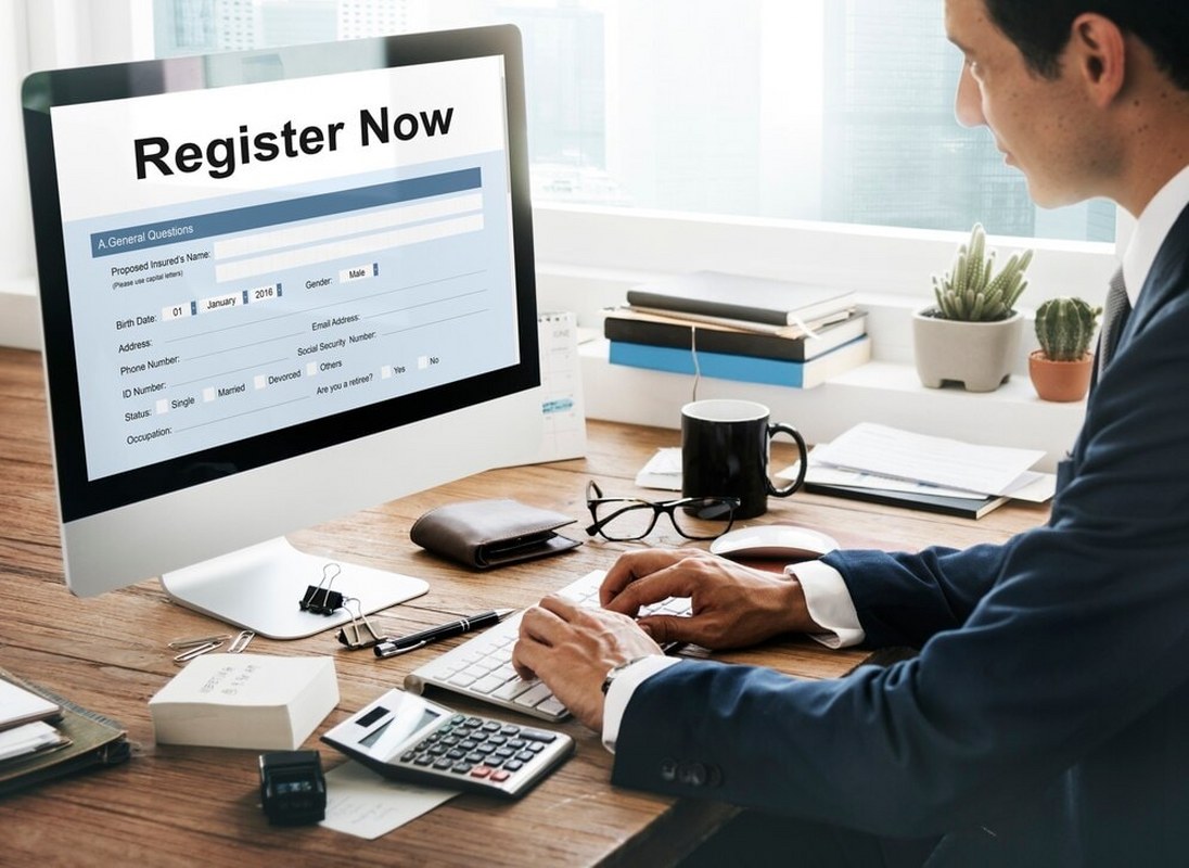 Man is filling out a registration form on his computer.
