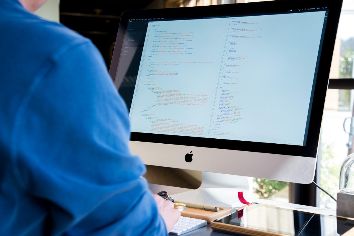 Man is looking at a code on the screen.