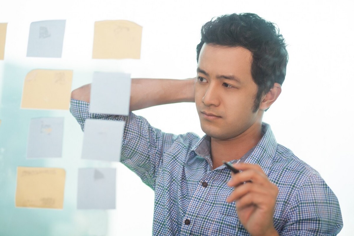 Mas is looking at adhesive notes.