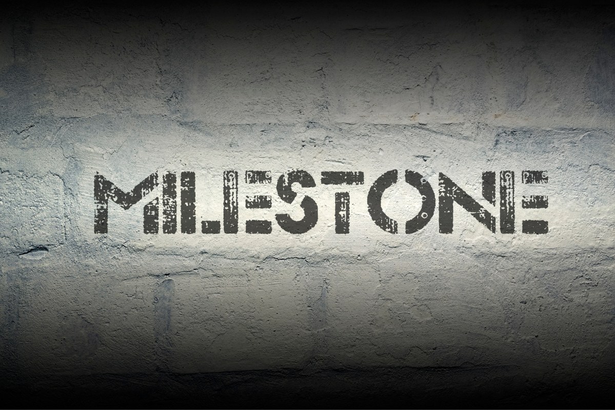 Milestone stencil print on concrete wall.