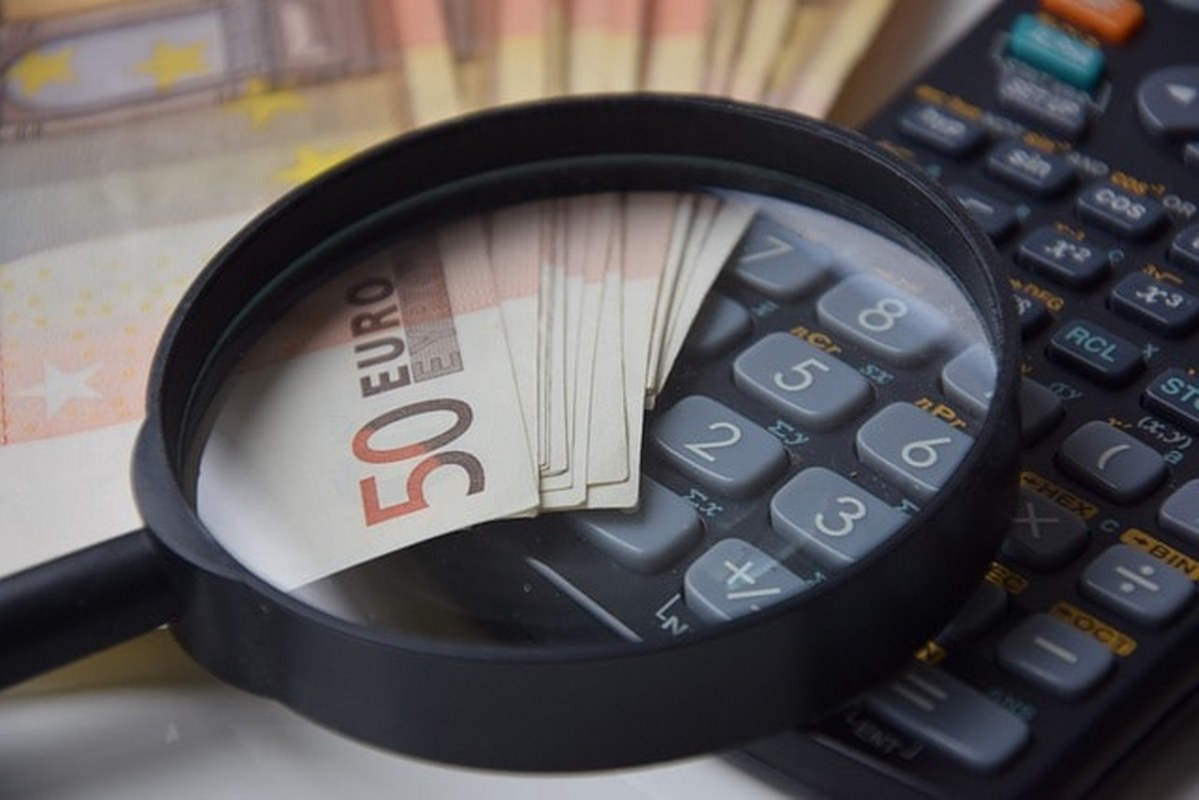 Money and a looking glass on a calculator.