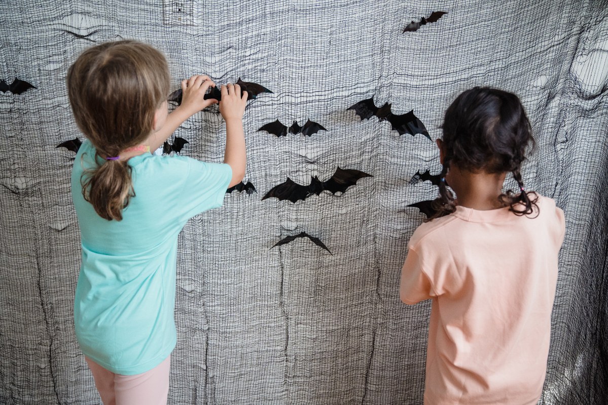 Rear view on kid pinning bats for Halloween.