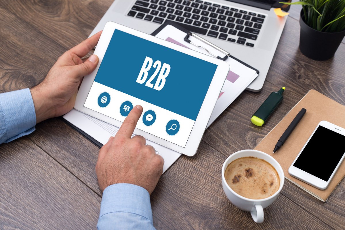 Screen showing B2B while businessman holds tablet.