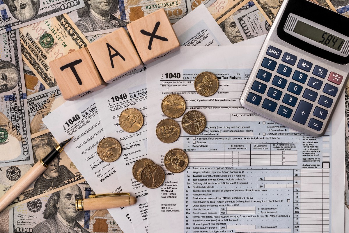 Taxation concept with wooden bricks and dollar coin.