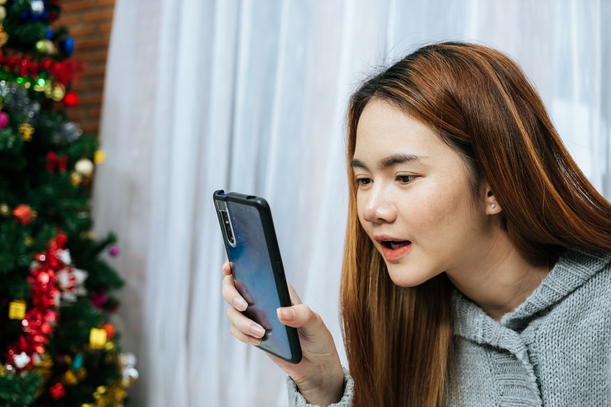 The girl is looking at her phone curiously.