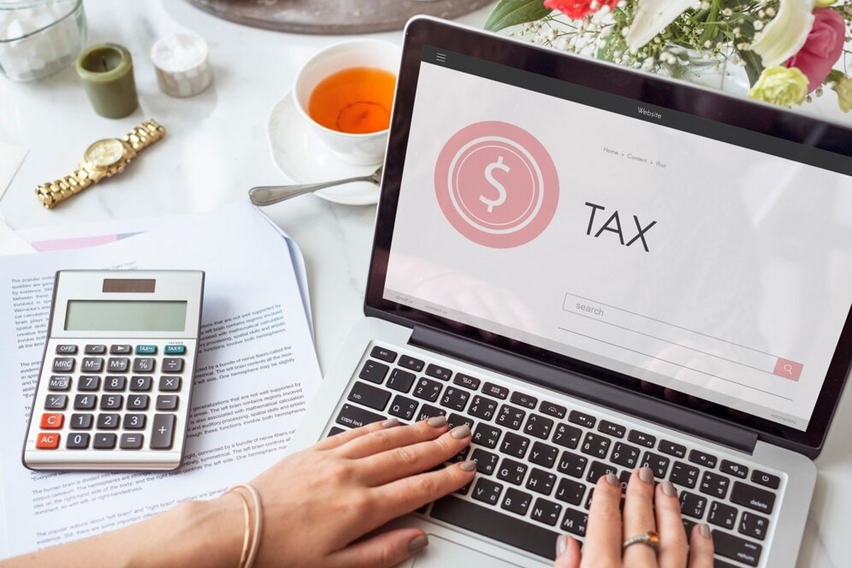The woman uses a laptop to take care of taxes.