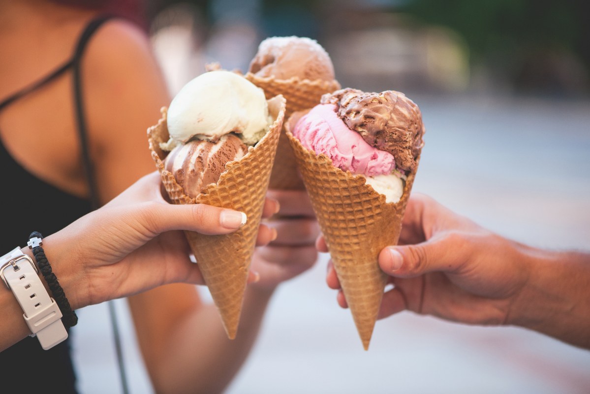 Three people holding together icecream.