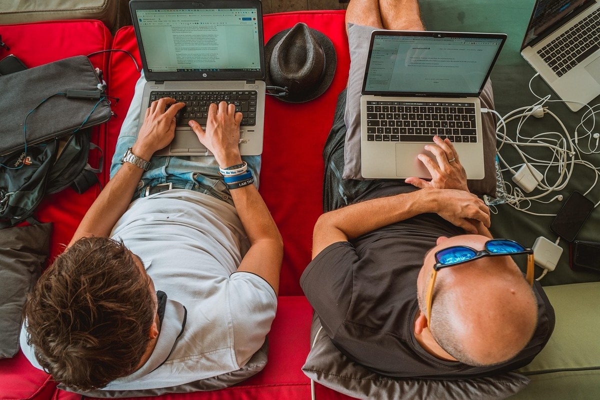 Two men working on their laptops.