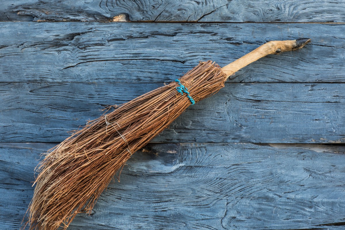 Witch broom on a wooden background.