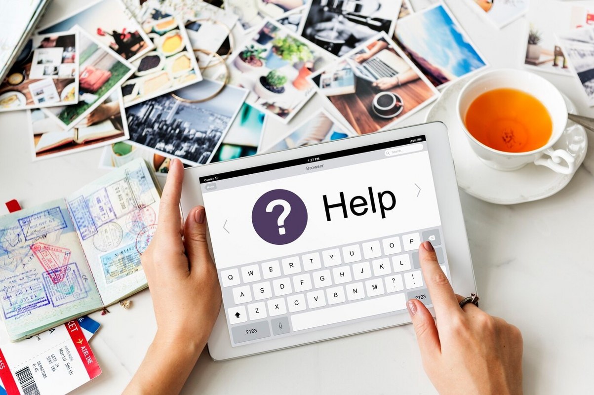 Woman is holding a tablet that displays a help screen.