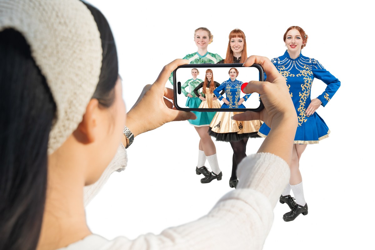 Woman live streaming three Irish dancers.