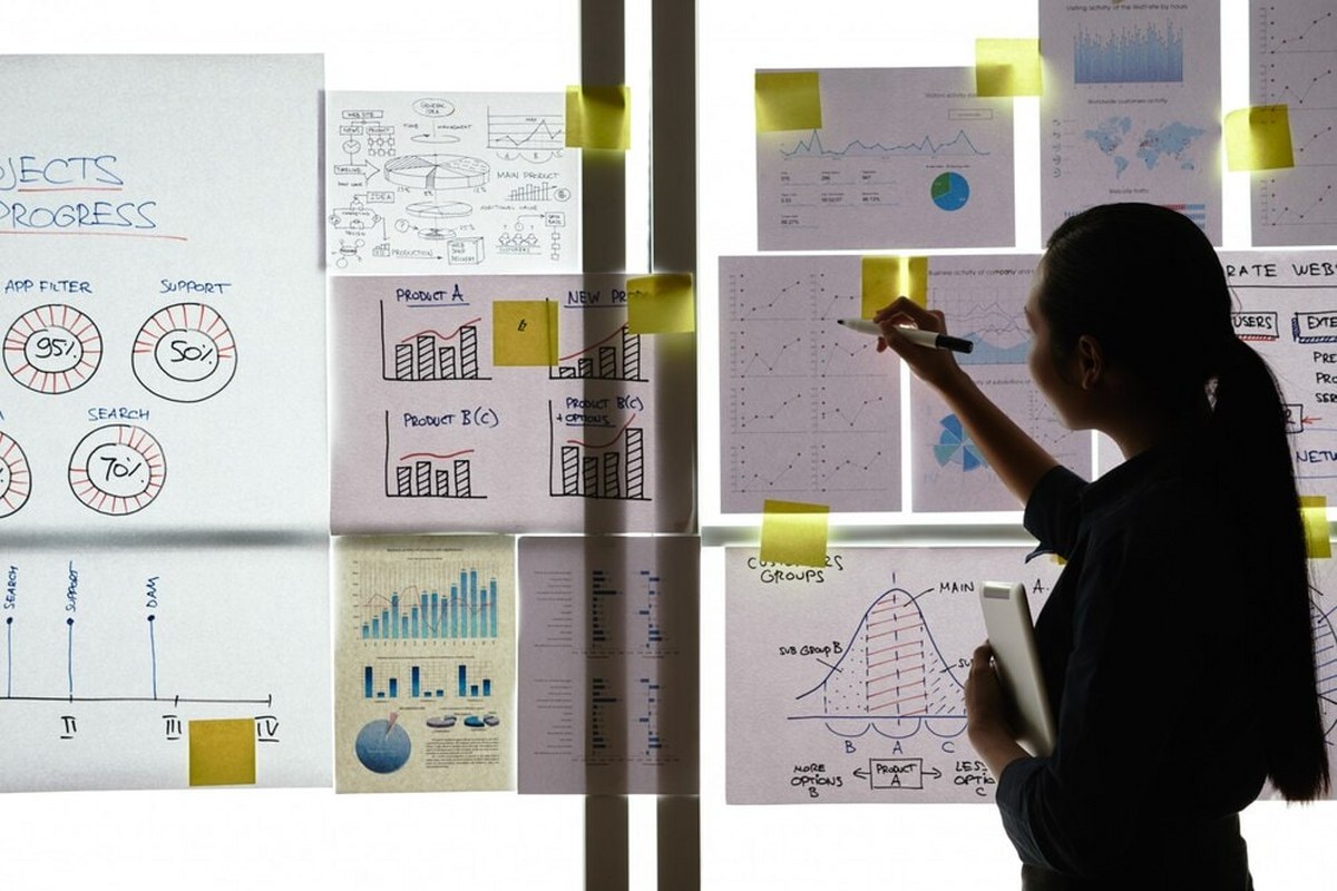 Woman shows a matrix on paper on a board.
