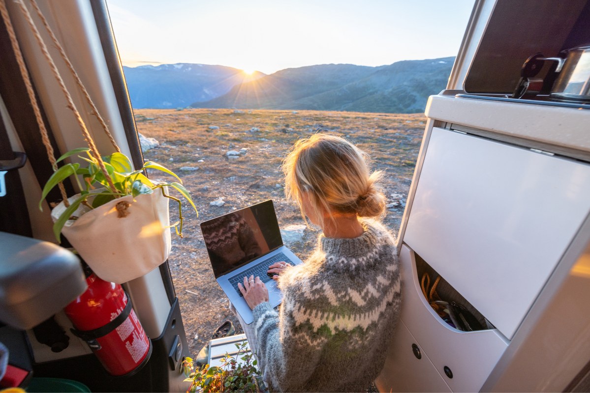 Woman working remotely, van life concept.