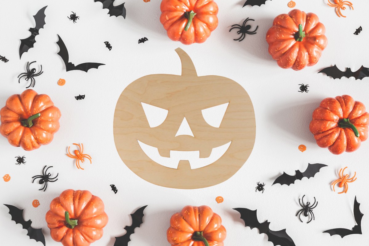 Wooden Jack-o'-lanterns flatlay with halloween decor at the back.