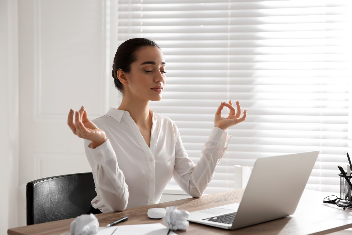 Young Businesswoman Meditating at Workplace.
