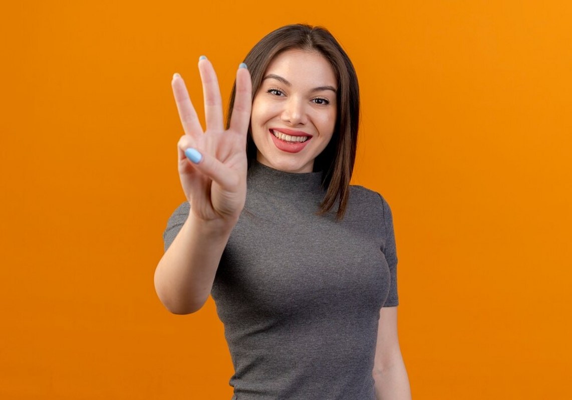Young pretty woman showing three with hand.