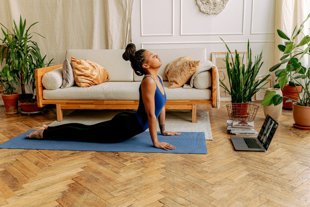 A Woman Exercising at Home doing online yoga.