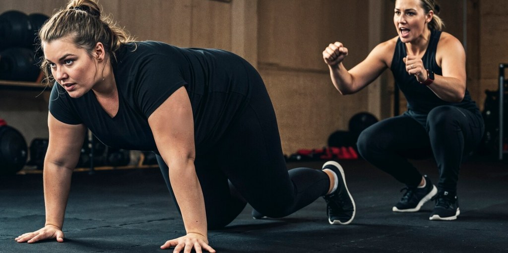 A fitness instructor guiding a student.
