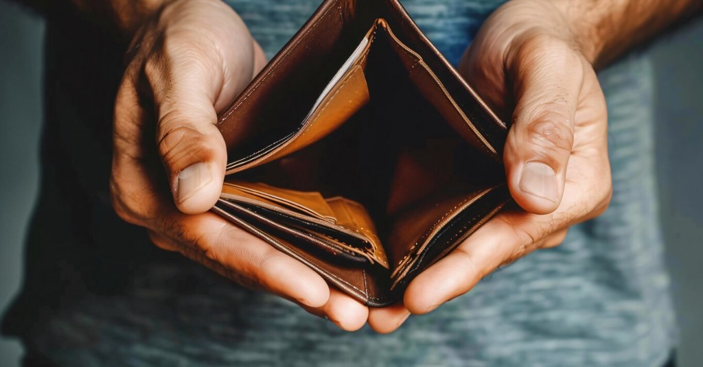 A money holding an empty wallet.