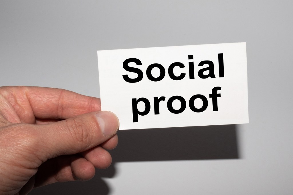 Message on the card SOCIAL PROOF in hands of businessman.