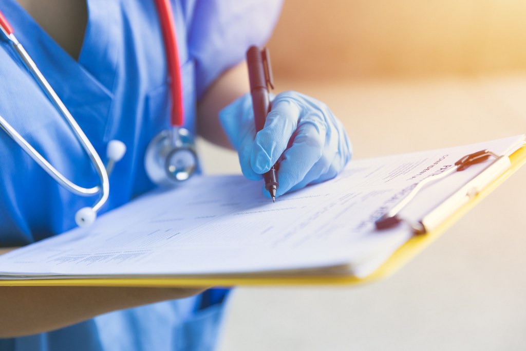 Nurse with medical document on hand.