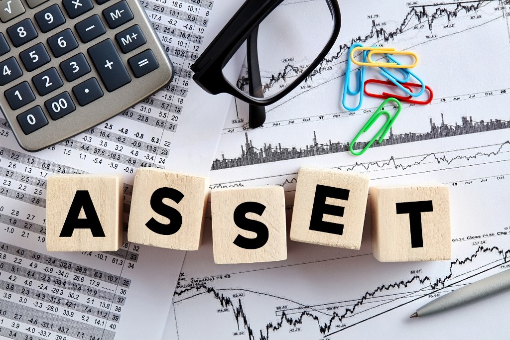 The word asset on wooden cubes with office desktop.
