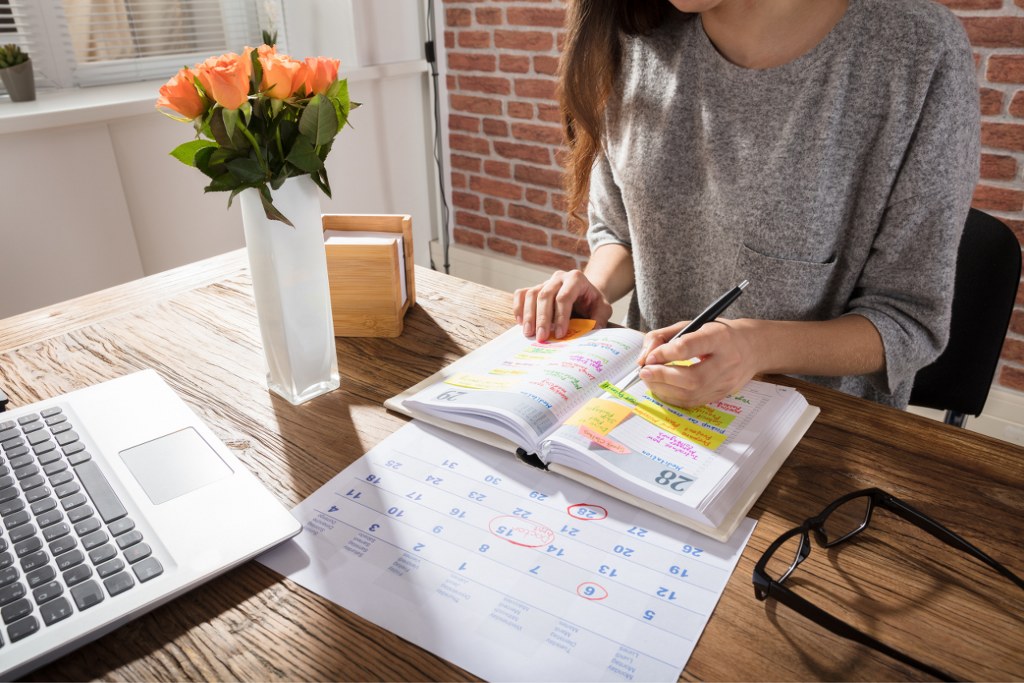 Woman Writing on a Planner.