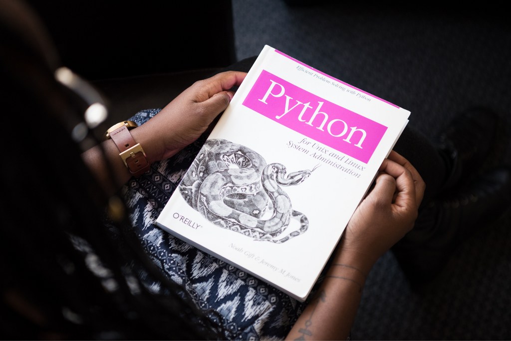 Woman reading python book.