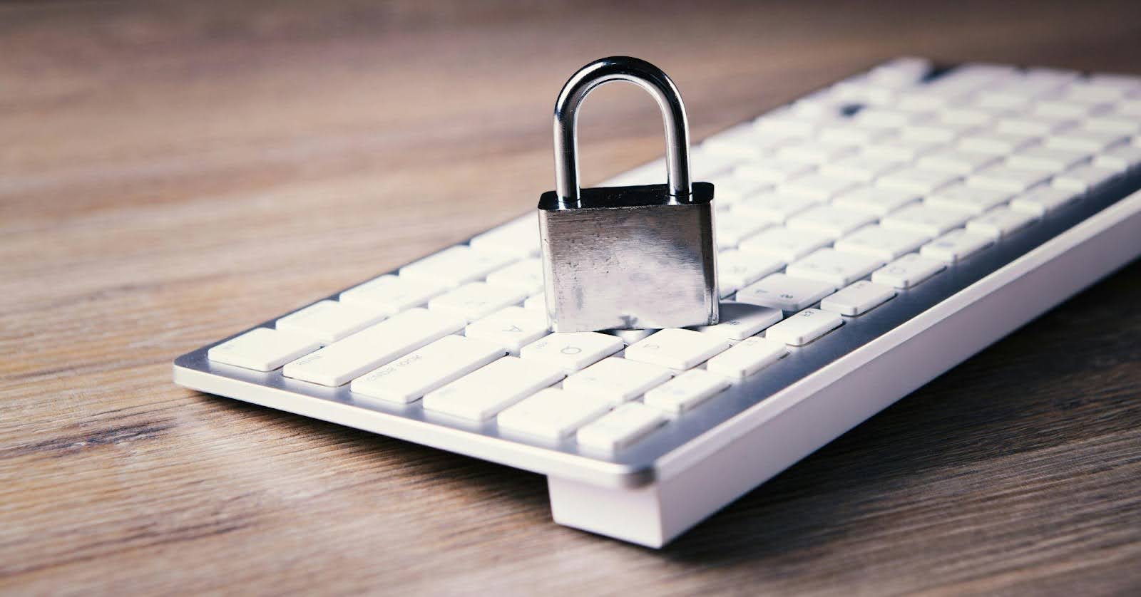 A computer keyboard with a padlock on top of it