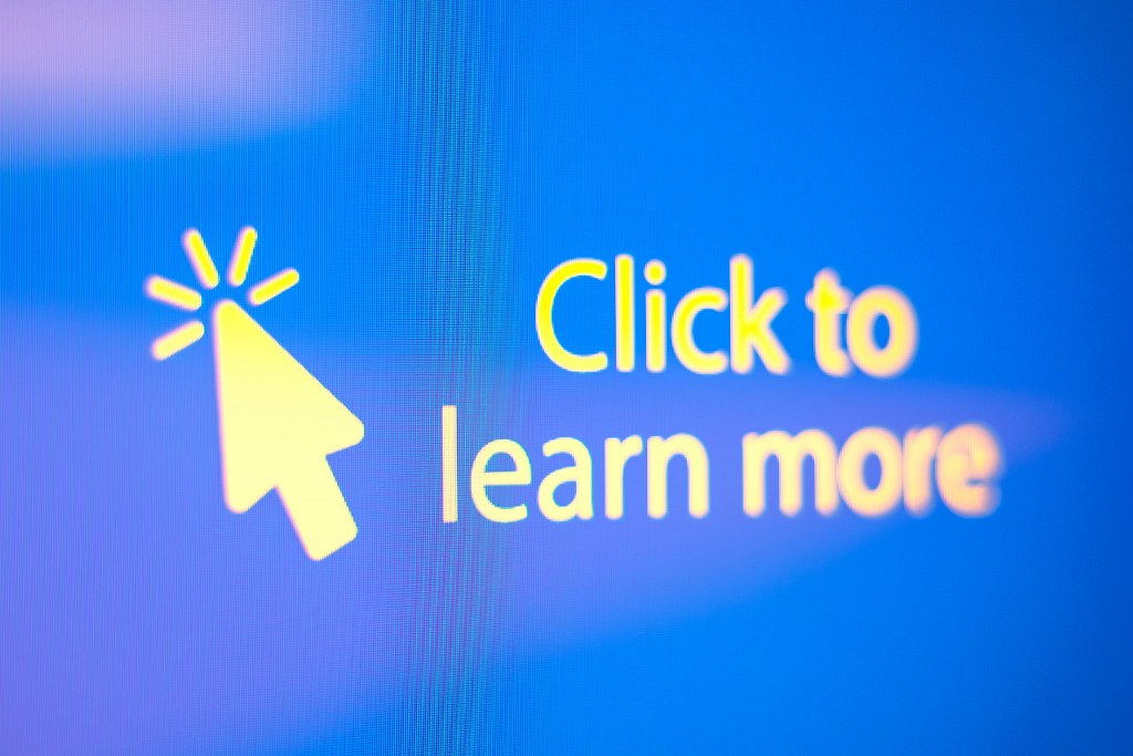 Click To Learn More Text And Arrow Sign On The Close-up Monitor Screen.